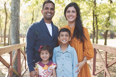 Family on a walking bridge in a Katy, TX master-planned community park.