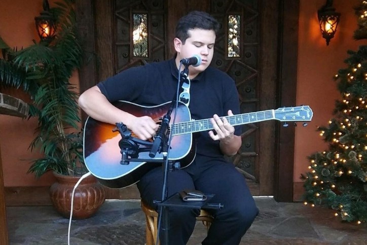 Alejandro Miramontes playing guitar at Elyson Cafe