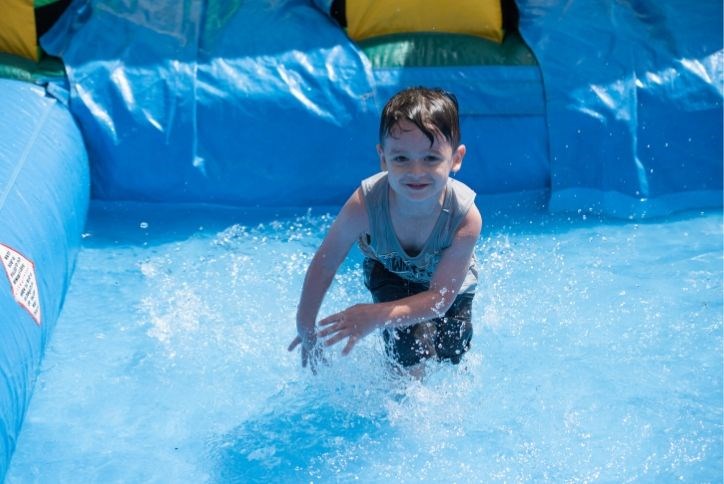 Kid playing water at Elyson's Back to Cool event.