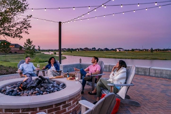 Residents relaxing by the Elyson fire pit at sunset.