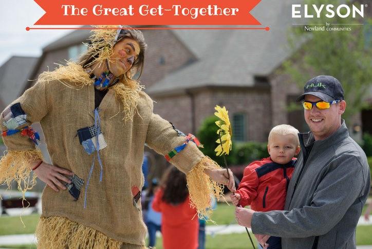 Scarecrow character with family at Elyson event.