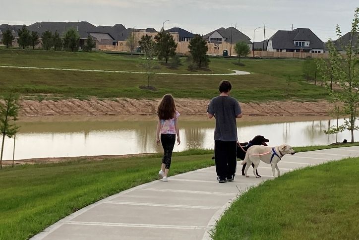 family walking their dog along trails in Elyson