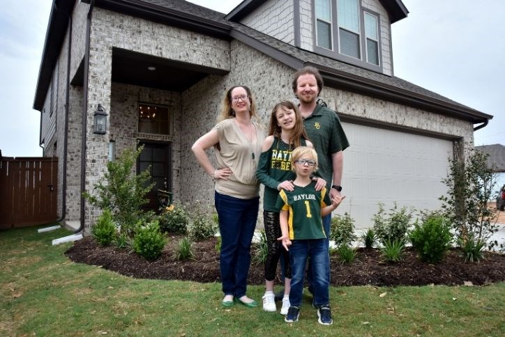 Clark Family smiling in front of their new home in Elyson