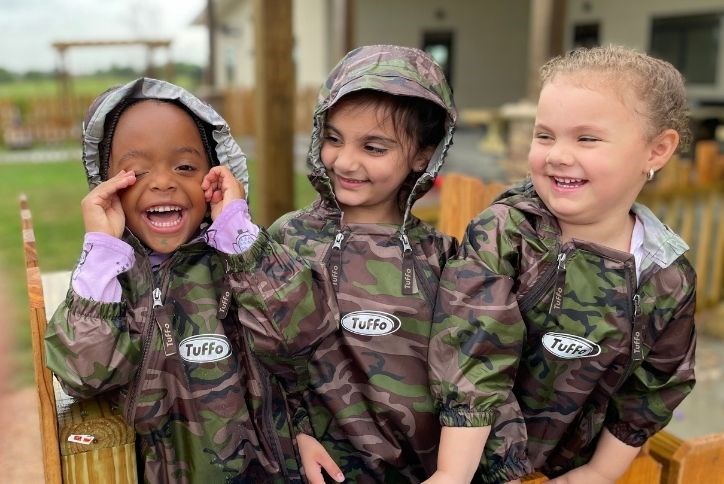 Students laughing in rain suits at Magnolia Prep Academy in Elyson in Katy, TX.