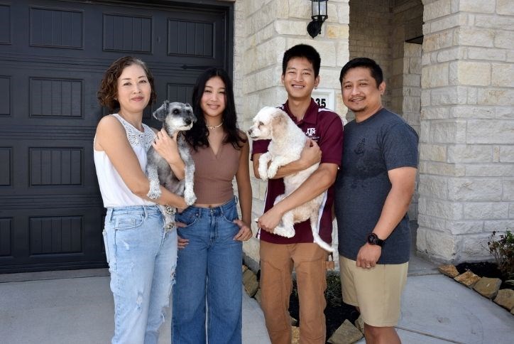 New residents in Elyson pose in front of their home with their dog