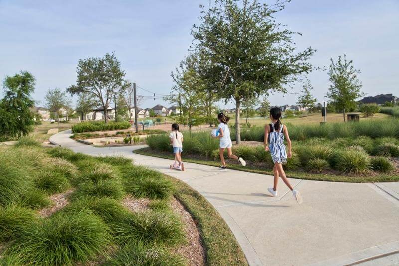 Kids running and scootering on sidewalk at Timber Grove Park Elyson Katy, TX