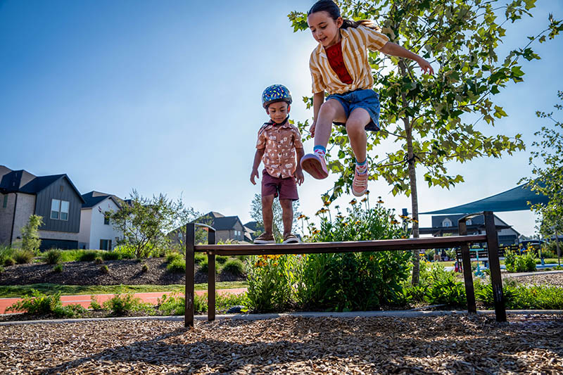 two kids playing on park bench