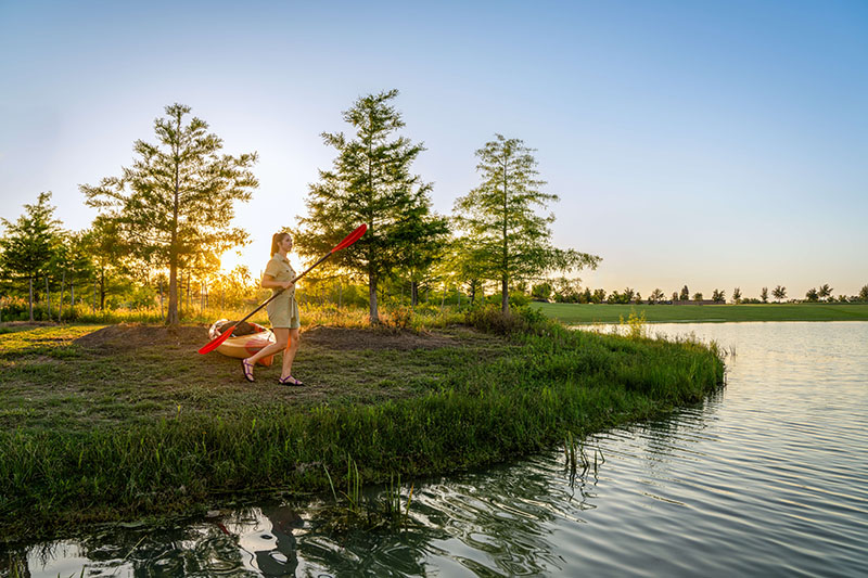 Woman Pulling Kyak To Water in park