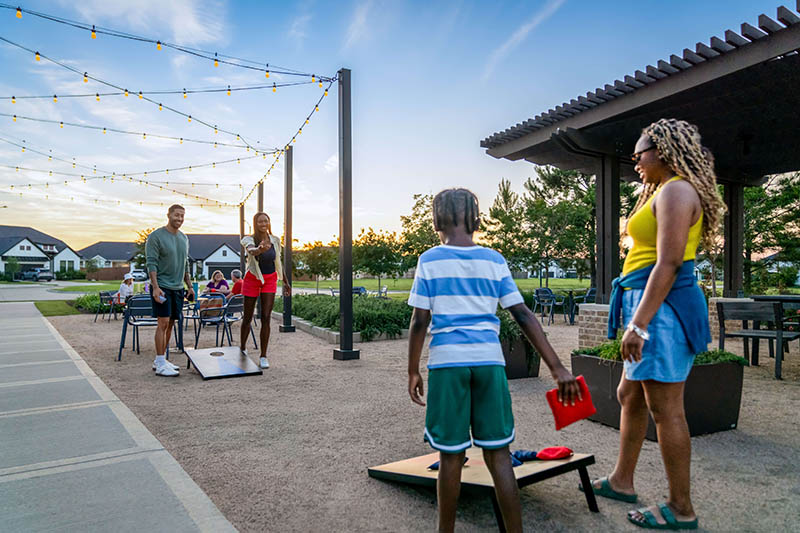 family playing yard games in the park
