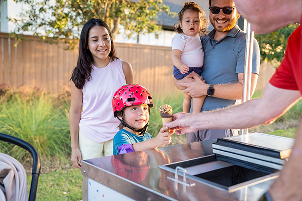 family getting ice cream cone from cart vendor